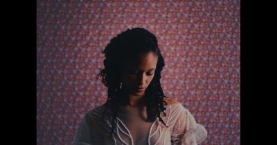 a woman standing in front of a red wall