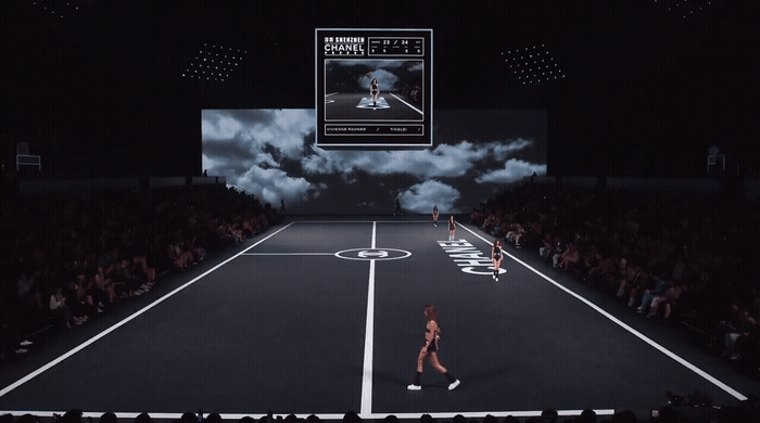 a woman walking across a tennis court in front of a crowd