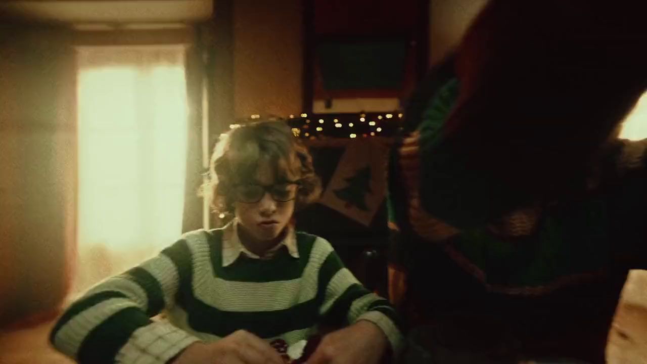 a young boy sitting at a table in front of a laptop computer