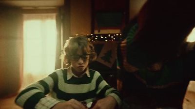 a young boy sitting at a table in front of a laptop computer