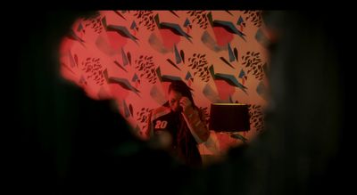 a woman standing in front of a red wall