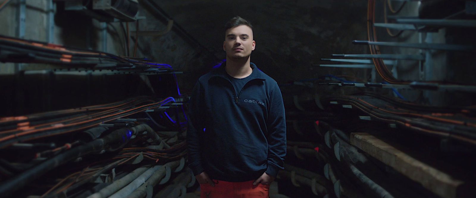 a man standing in front of a bunch of pipes