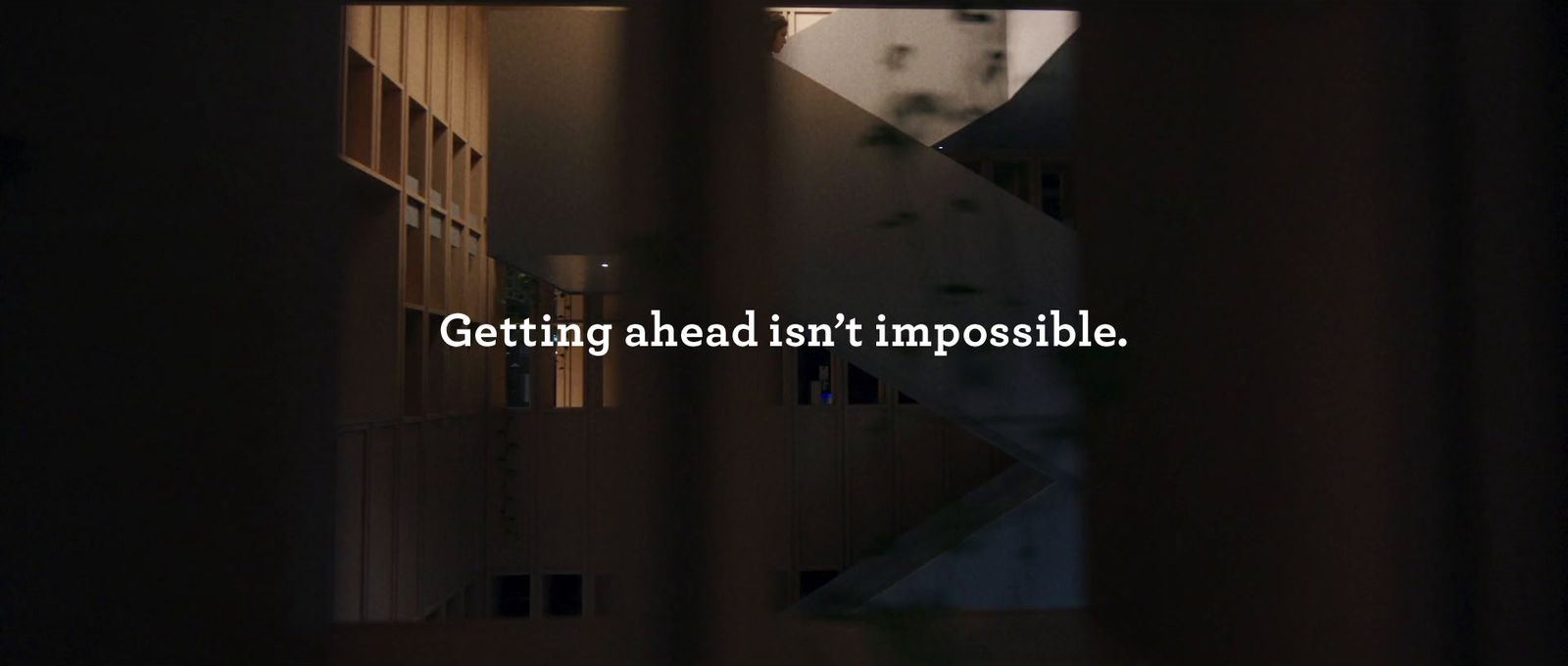 a picture of a building with a quote about getting ahead isn't impossible