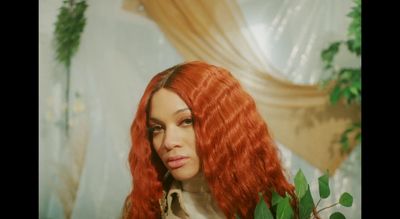 a woman with long red hair is posing for a picture