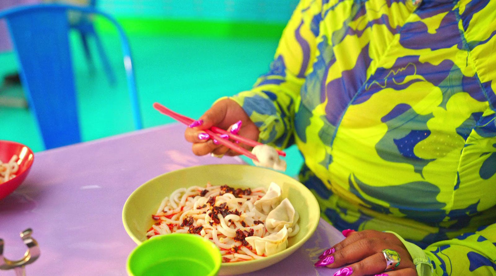 a woman sitting at a table with a bowl of food