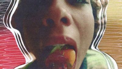 a woman eating a piece of fruit with her mouth open