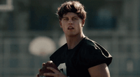 a young man holding a football in his right hand