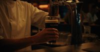 a person pouring a beer into a glass