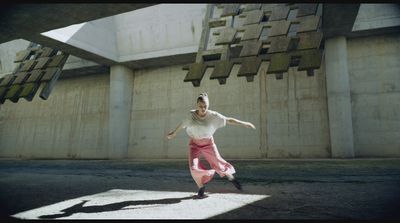 a woman in a white shirt and pink skirt