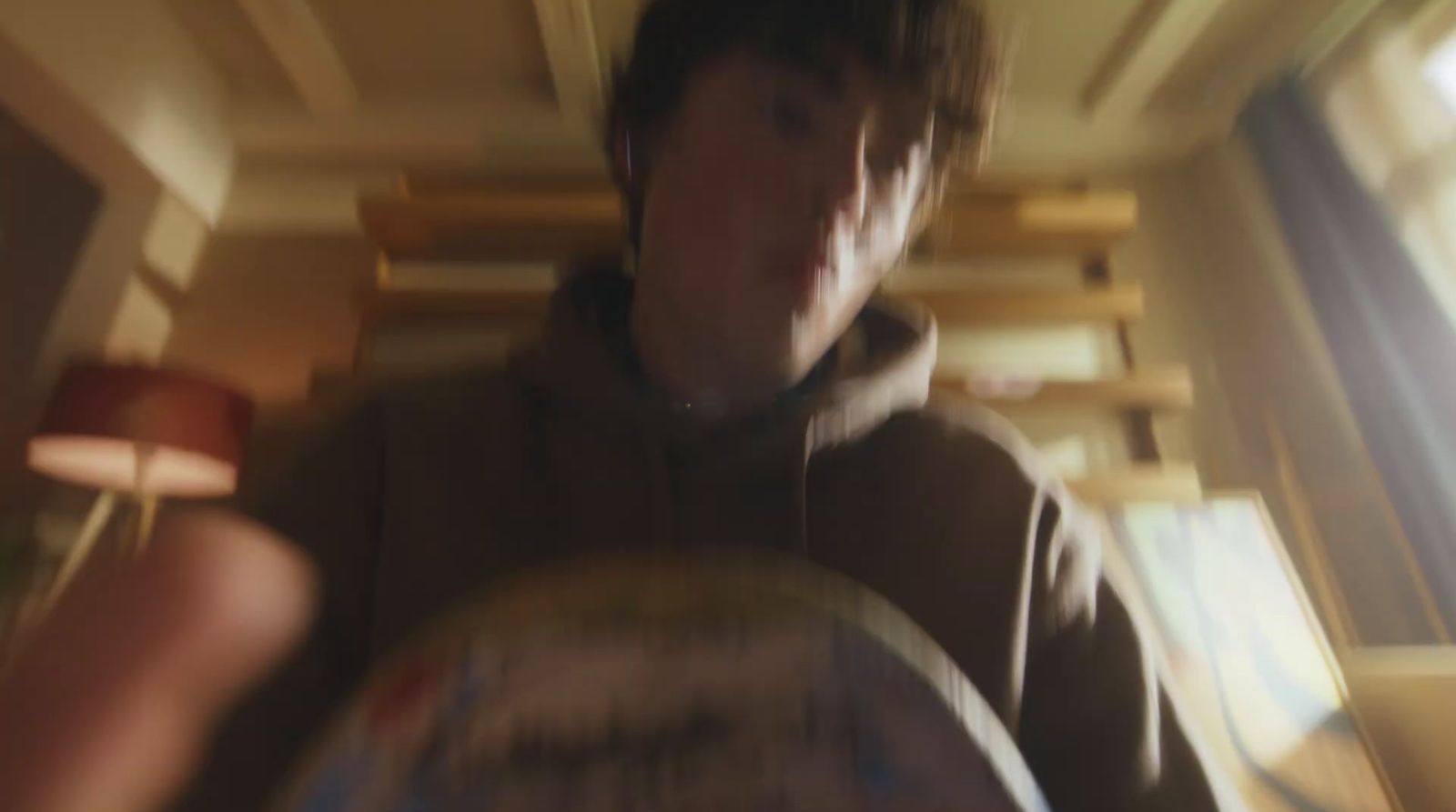 a blurry photo of a man in a brown hoodie