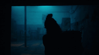 a person standing in a dark room with a suitcase