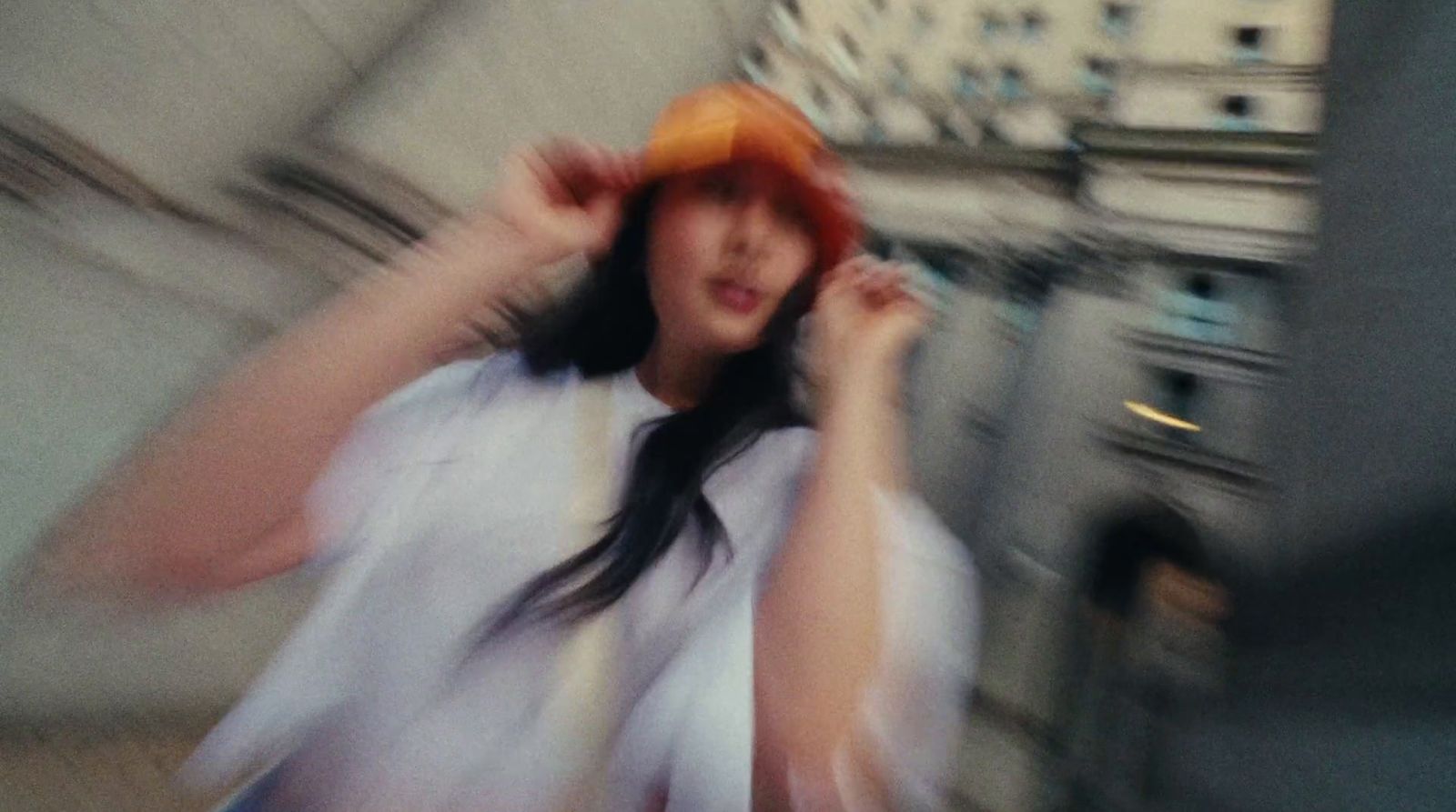 a woman in a white shirt and orange hat