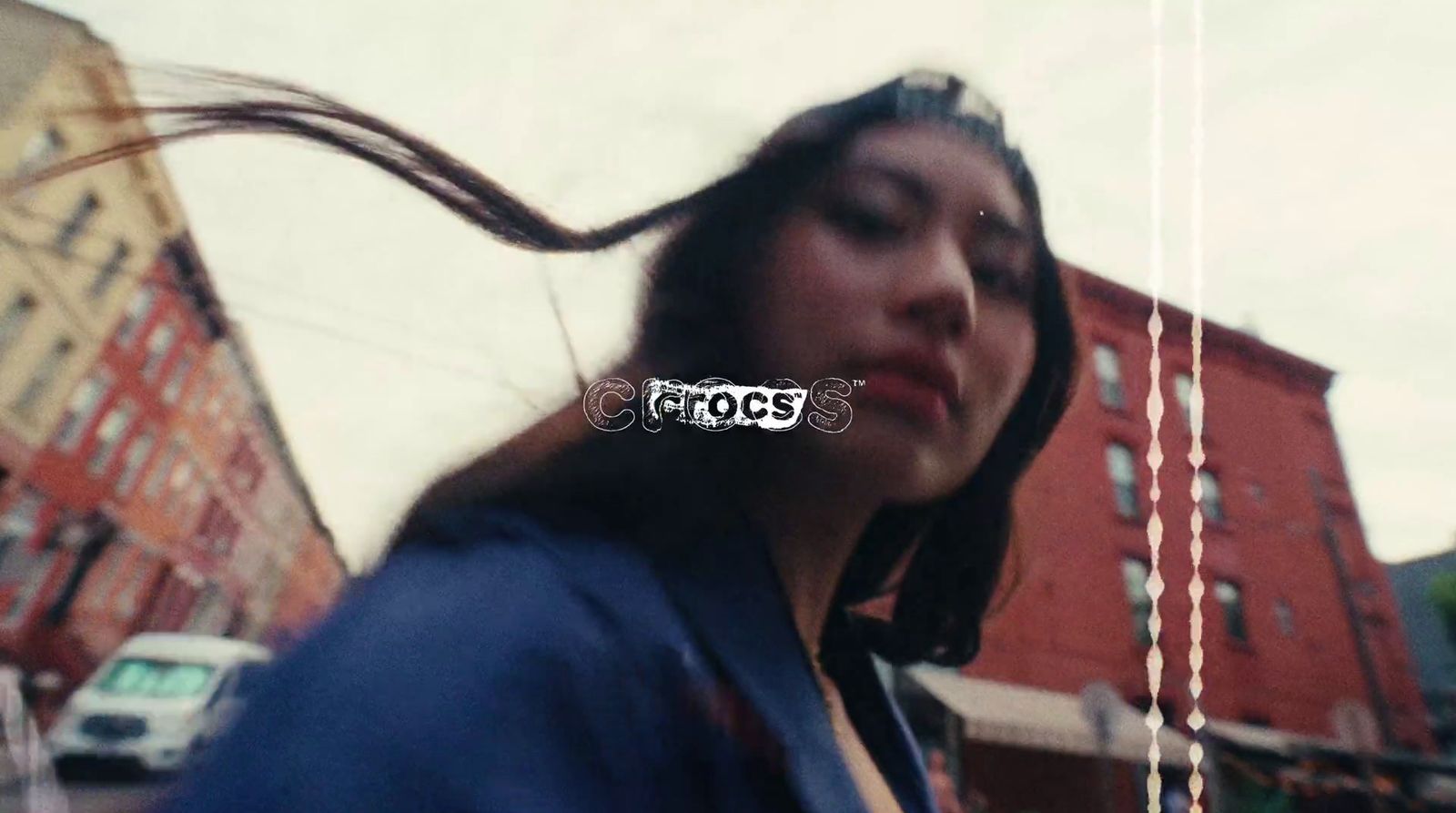 a woman with long hair standing in front of a building