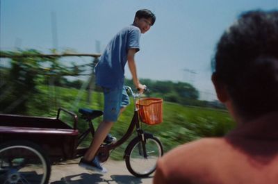 a man riding a bike with a basket on the back of it