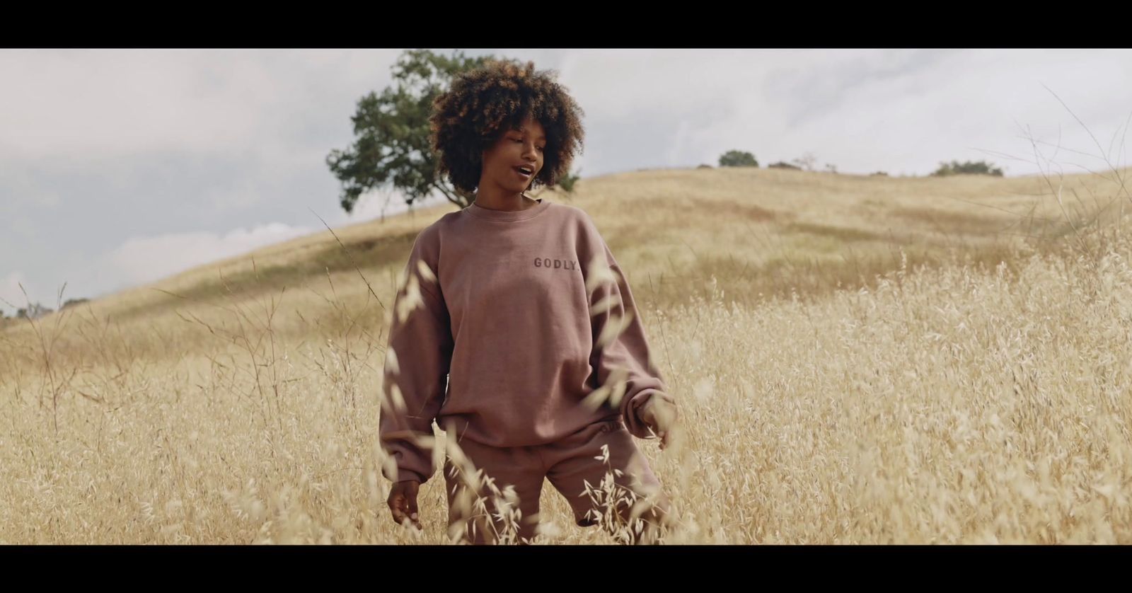 a woman standing in a field of tall grass