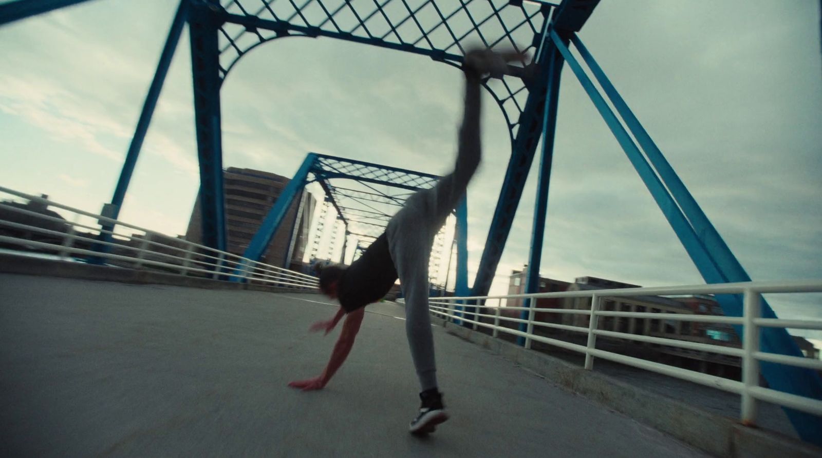 a skateboarder is doing a trick on a bridge