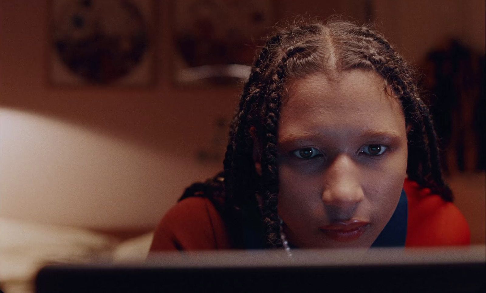 a woman with dreadlocks looking at a computer screen