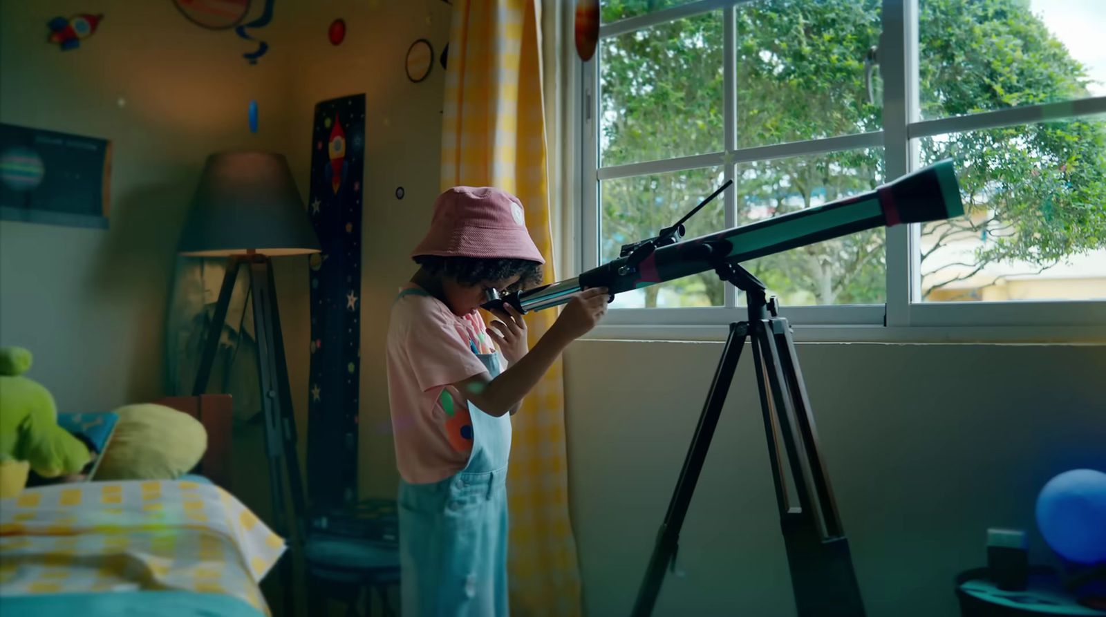 a young girl is looking through a telescope