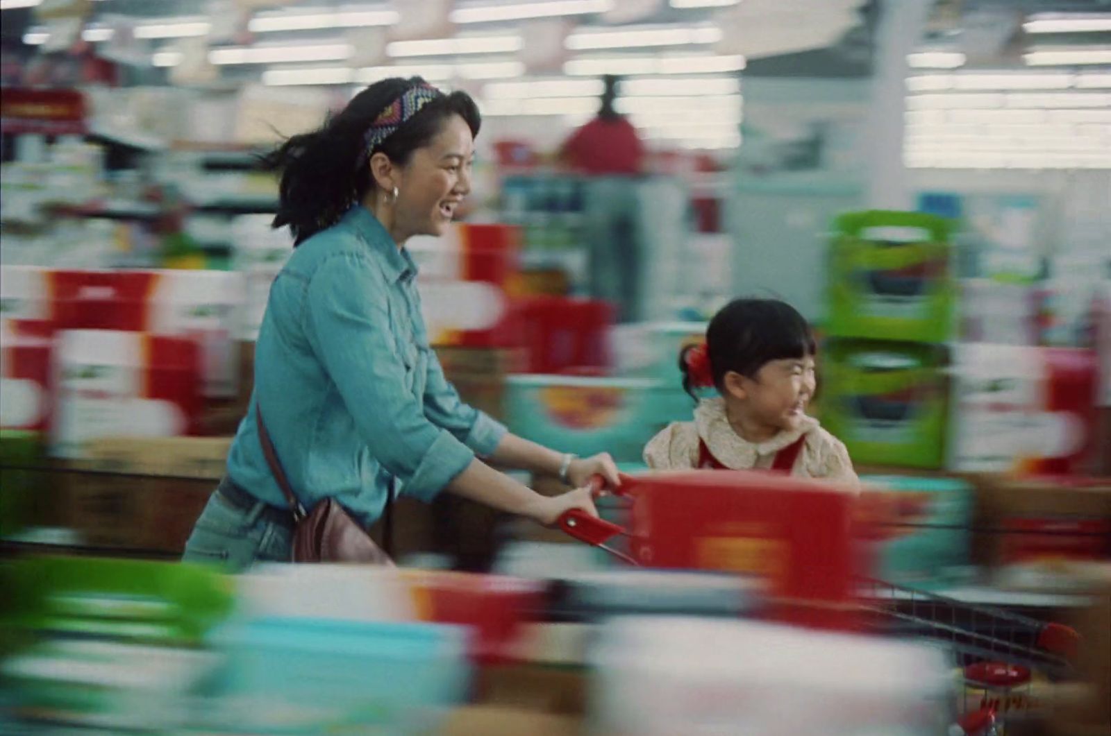 a woman pushing a child in a shopping cart