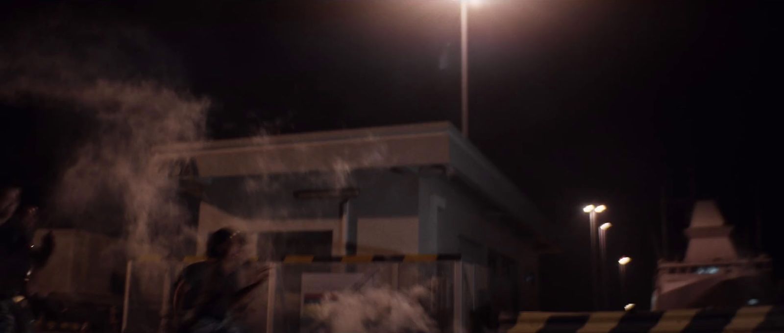 a man standing next to a street light at night