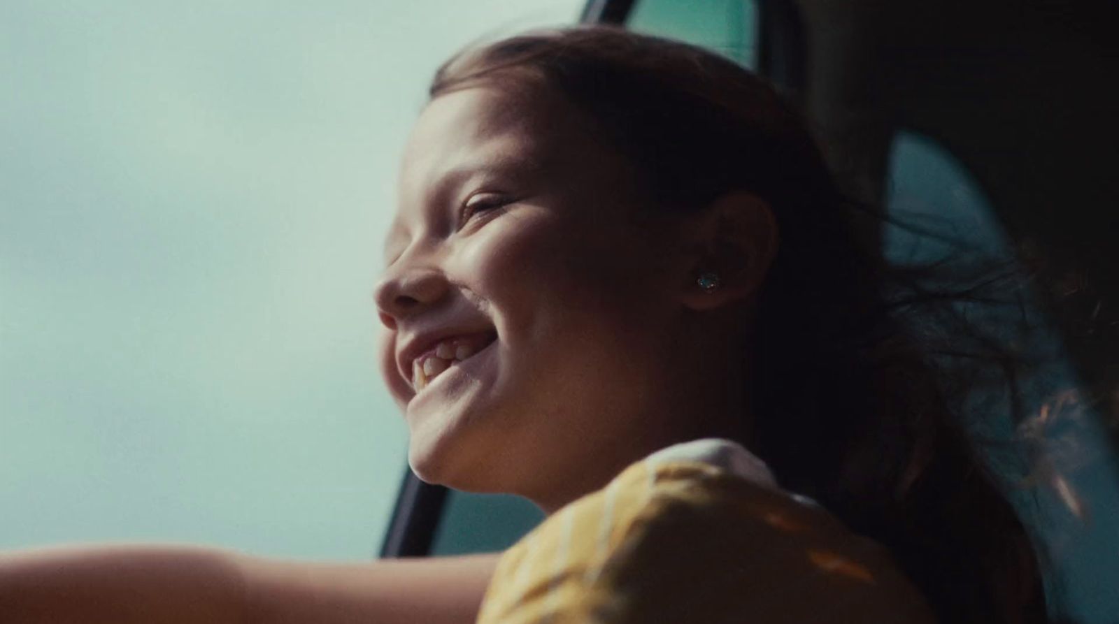 a woman is smiling while sitting in a car