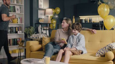 a man and a boy sitting on a couch in a living room