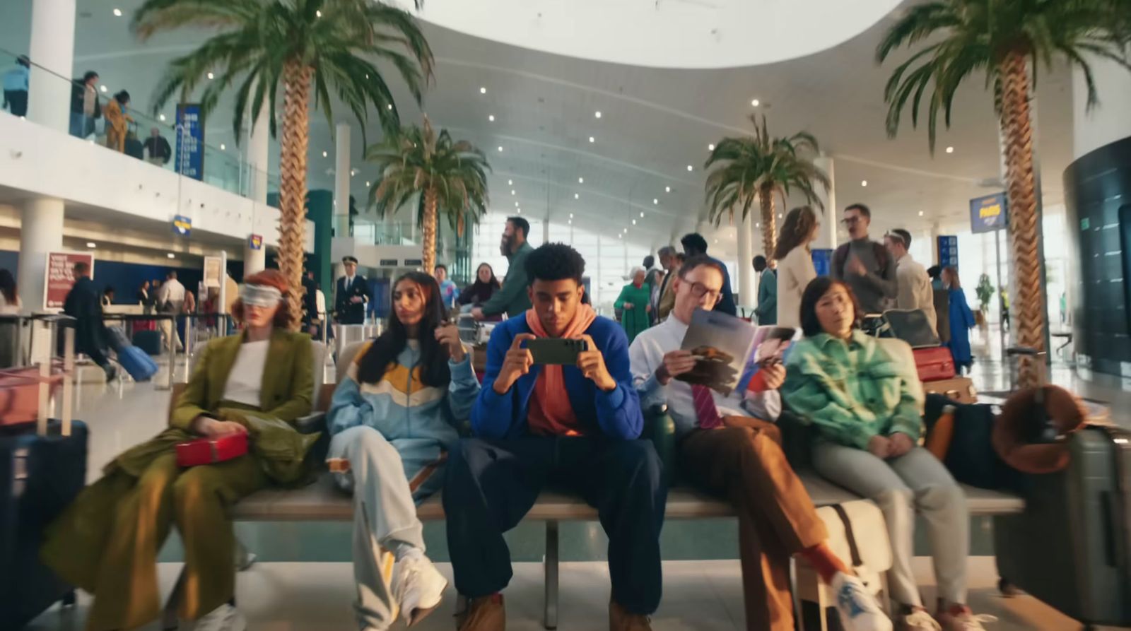 a group of people sitting on a bench in an airport