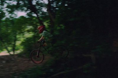 a man riding a bike through a forest