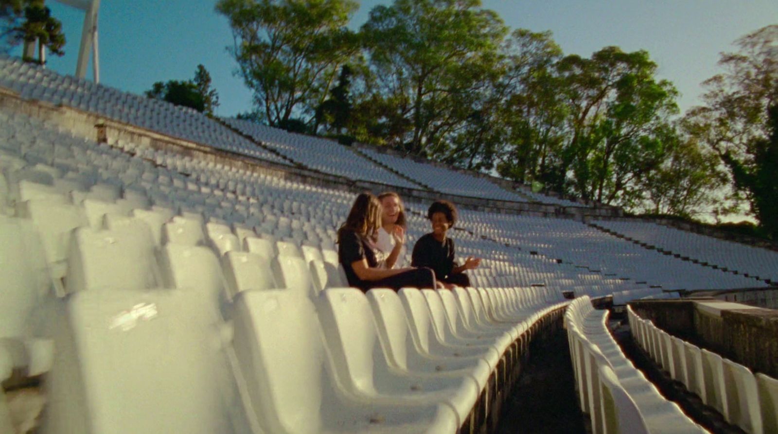 a couple of people sitting on a bleachers