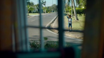 a young boy standing on the side of a road