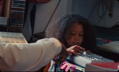 a young girl is playing a sound board in a recording studio