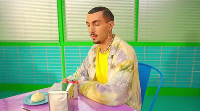 a man sitting at a table in front of a cake