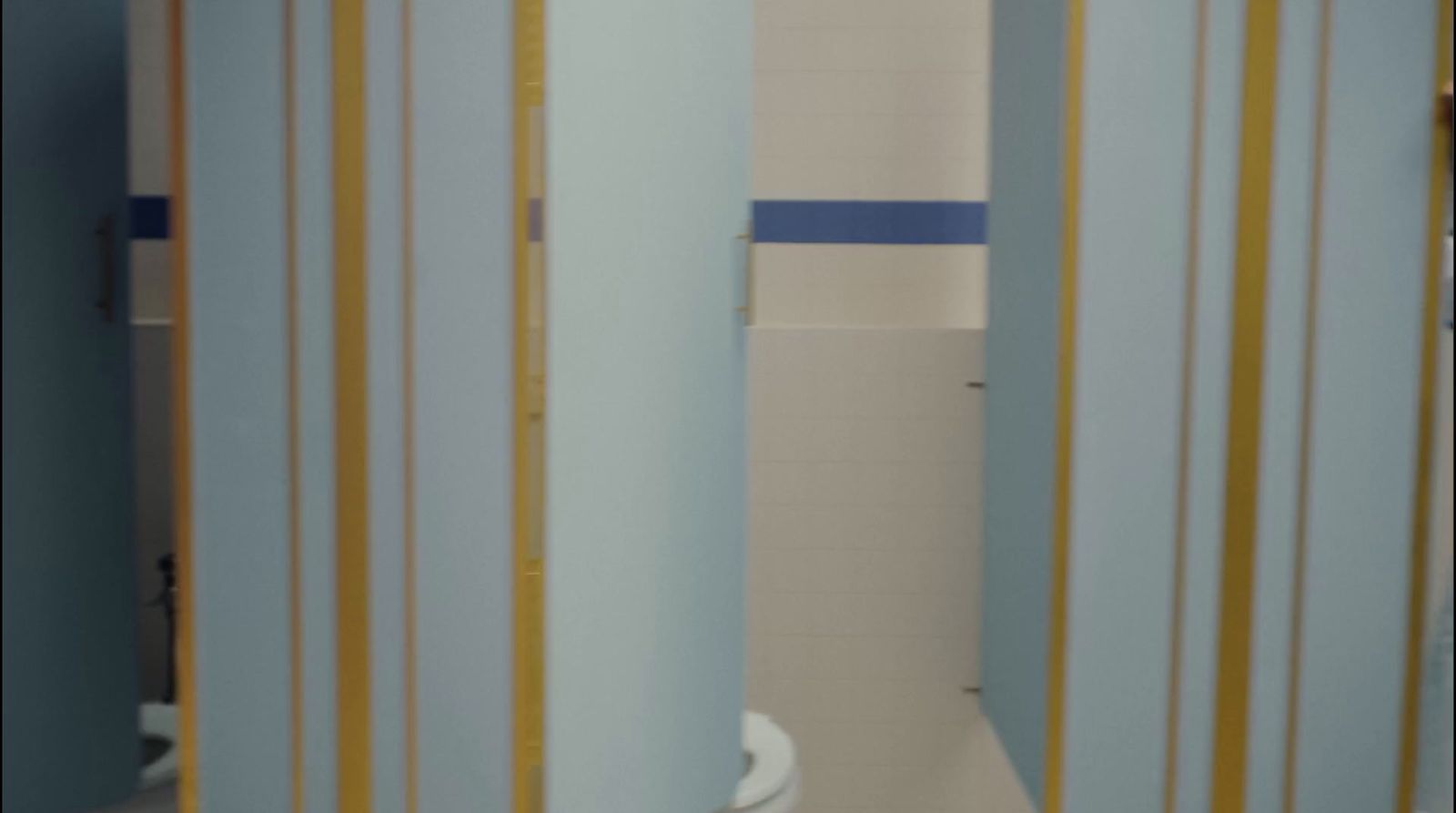 a white toilet sitting in a bathroom next to a blue and yellow wall