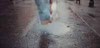 a person walking in the rain with an umbrella