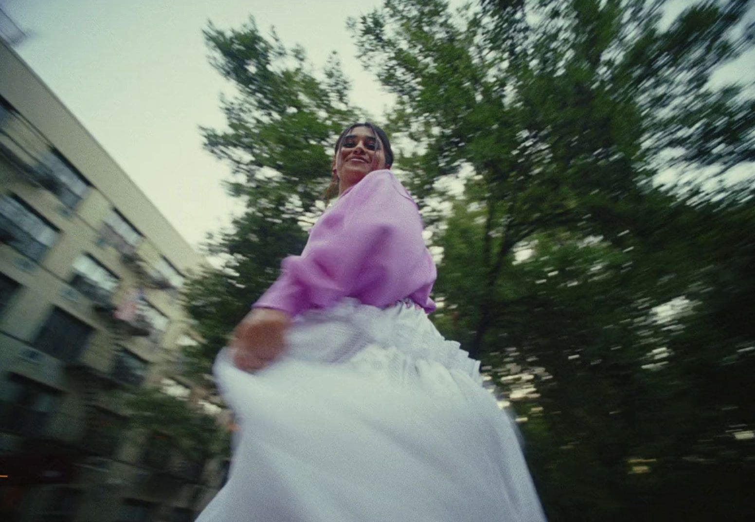 a woman in a white dress walking down a street