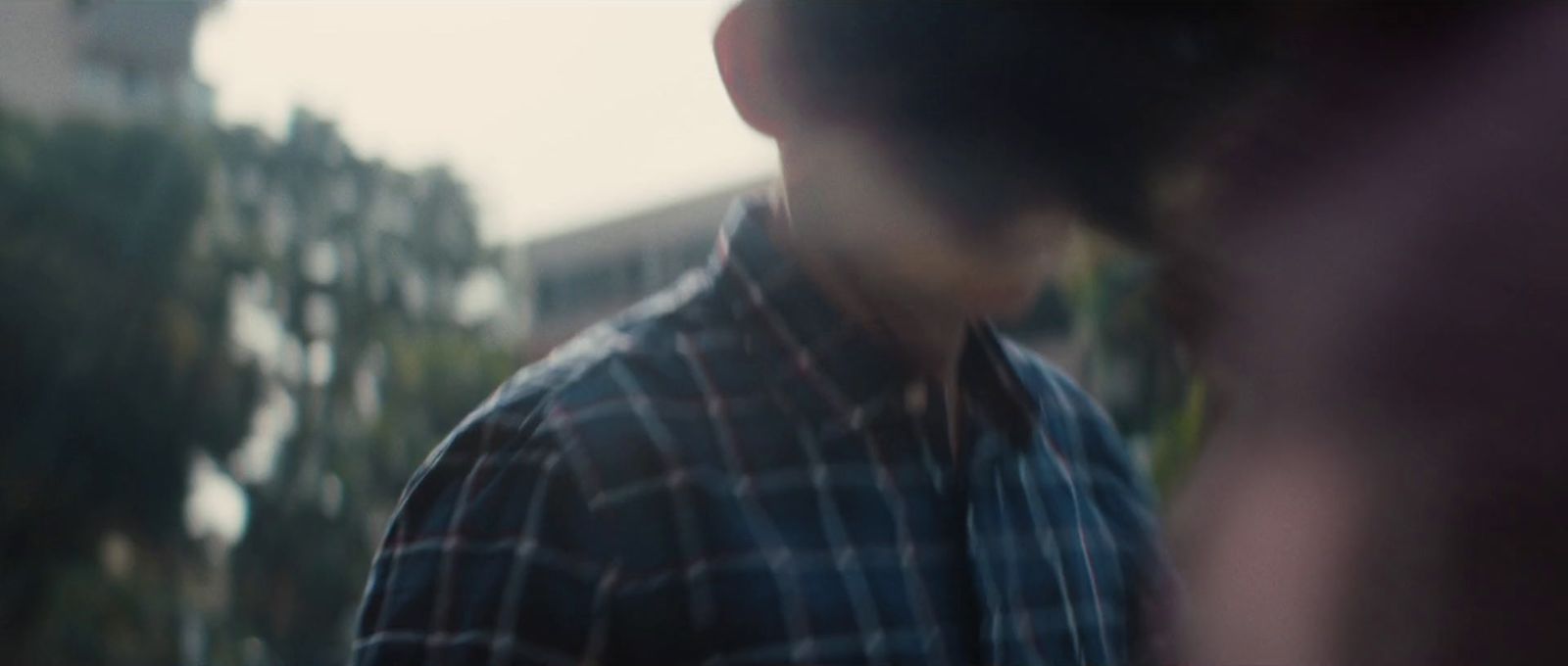 a blurry image of a man in a plaid shirt