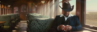 a man in a cowboy hat sitting on a train