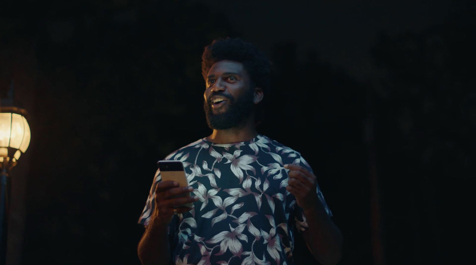 a man standing in the dark holding a cell phone