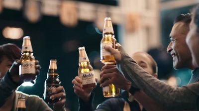 a group of people holding up bottles of beer