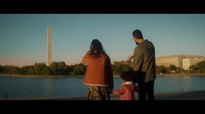 a family looking at the washington monument and reflecting in the water