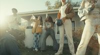 a group of people standing in front of a house