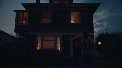 a person standing in front of a house at night