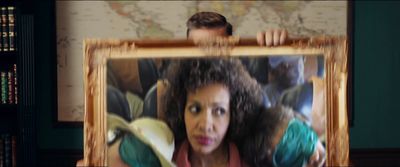 a woman holding a picture of a man behind her