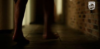 a close up of a person's legs with a brick wall in the background