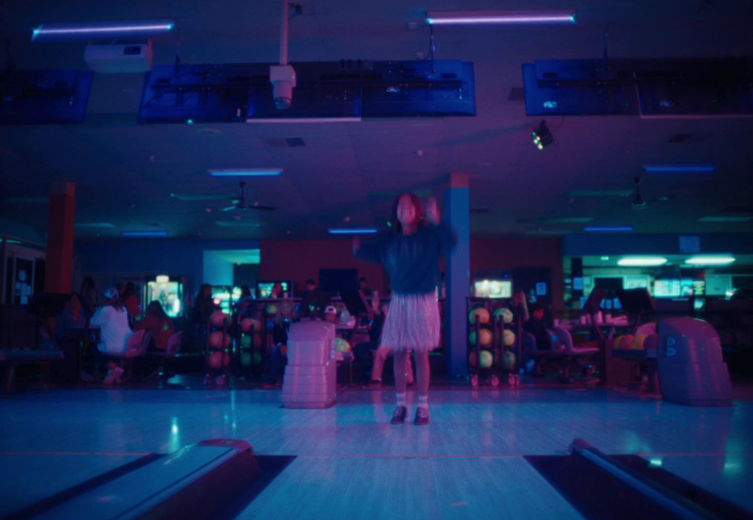 a couple of people that are standing in a bowling alley