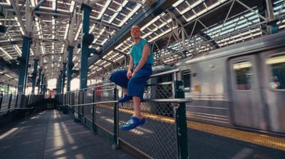 a woman sitting on a rail in a train station