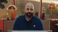 a man with a beard sitting in front of a laptop