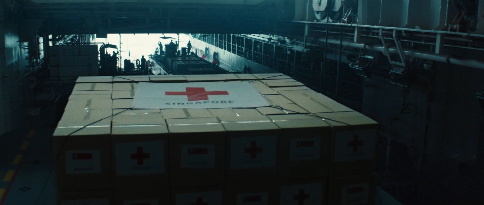 a box with a red cross on it sitting on a conveyor belt