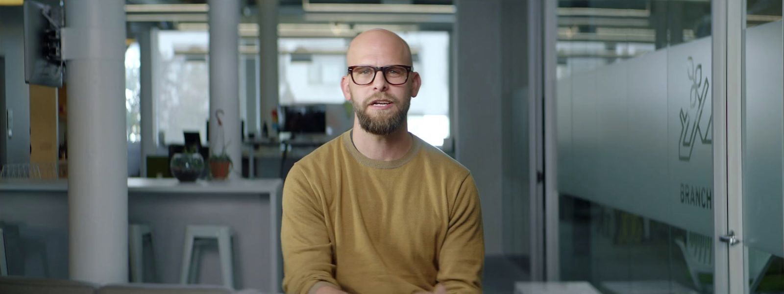 a man with a bald head wearing glasses