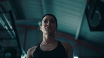 a woman standing in a gym looking up